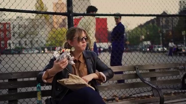Jane sitting on a bench surrounded by flowers