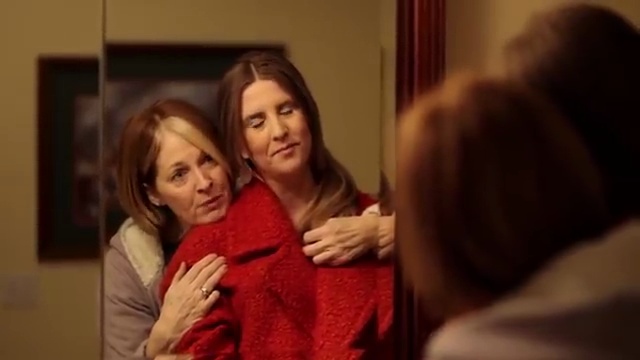 Jane's mother in a red coat reflected in a mirror